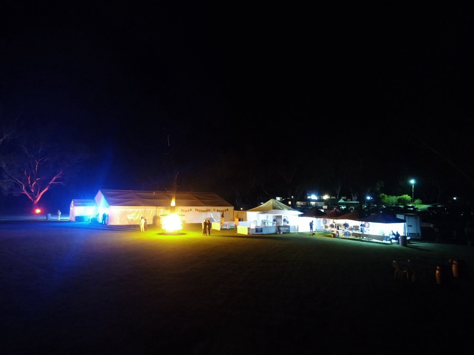 The Black Cockatoo evening at Johnny Mullagh Oval at night, the lit marquee and stalls on the oval