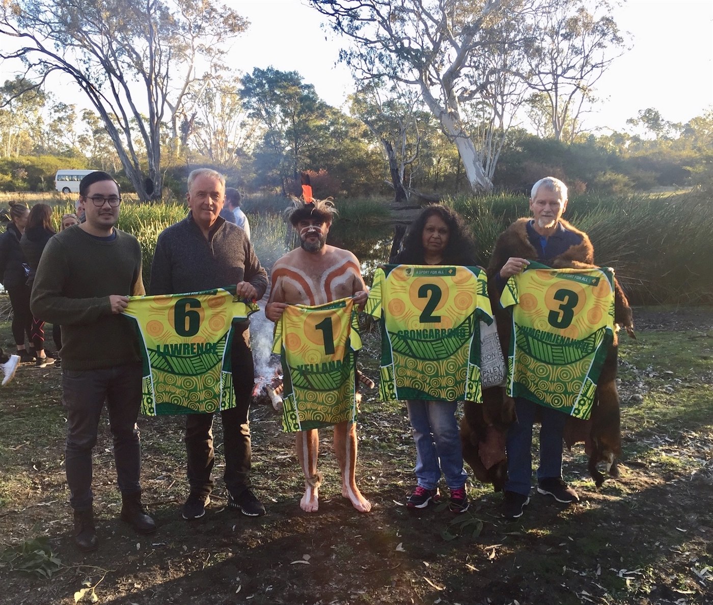 Descendants of the First XI at Johnny Mullagh's waterhole, each holding a First XI guernsey